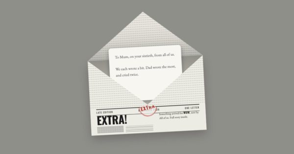 A newspaper-print envelope headlined “Extra!”, open, with a letter beginning “To Mum, on your sixtieth, from all of us”