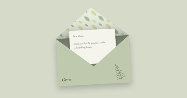 A sage-green envelope lined with leaves, open, with a letter to Gran beginning “Thank you for the jumper”